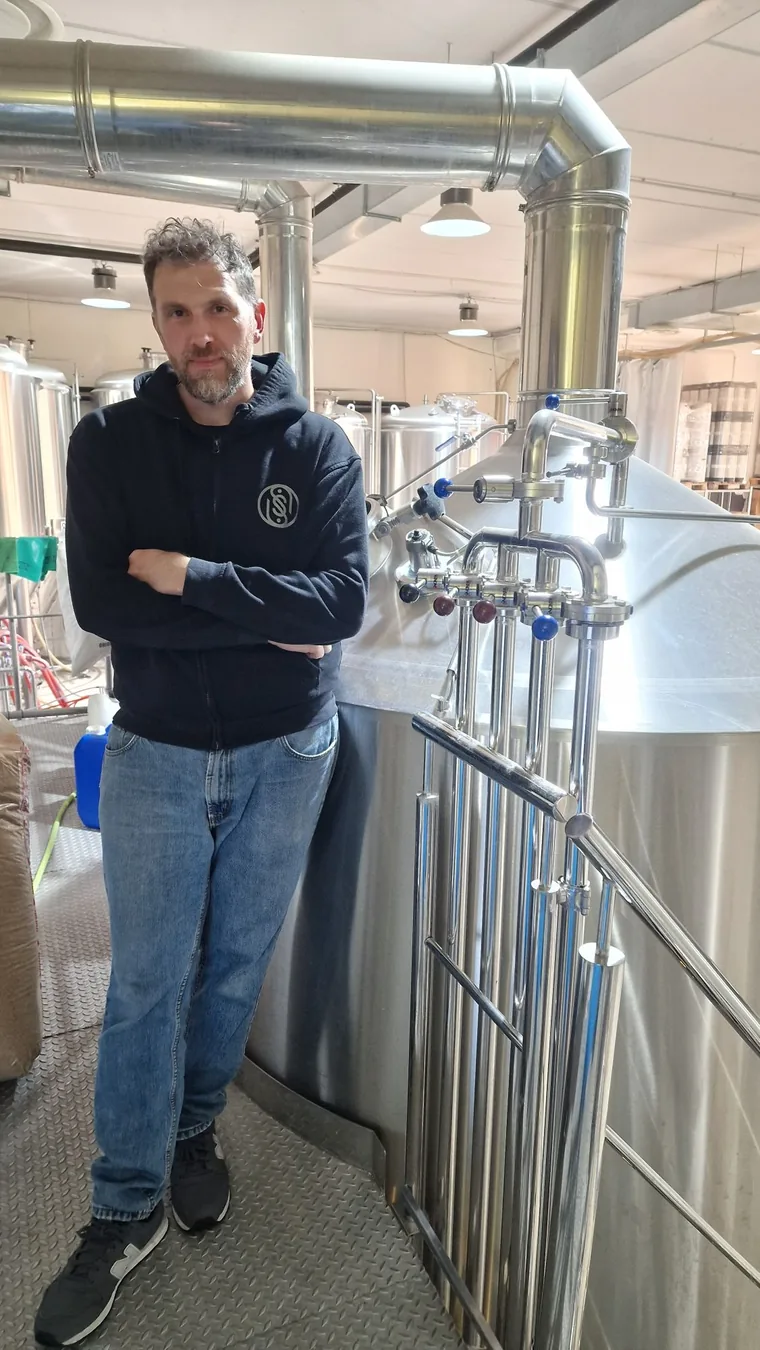 Salvatore, il birraio di South Soul, a braccia incrociate accanto ai tini del birrificio di Francolise